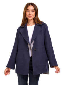 Woman wearing a navy blue alpaca jacket on a white background